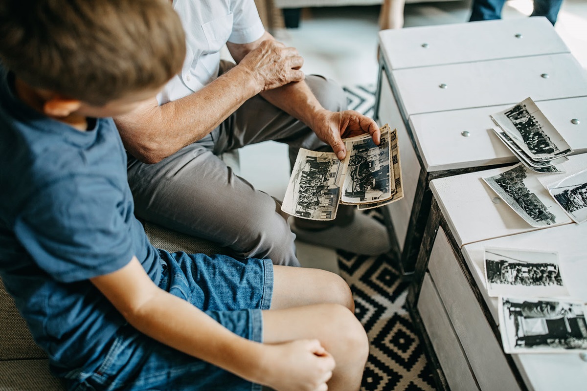 Before prepping his scanner, a grandfather shares old black and white photos with his grandson.