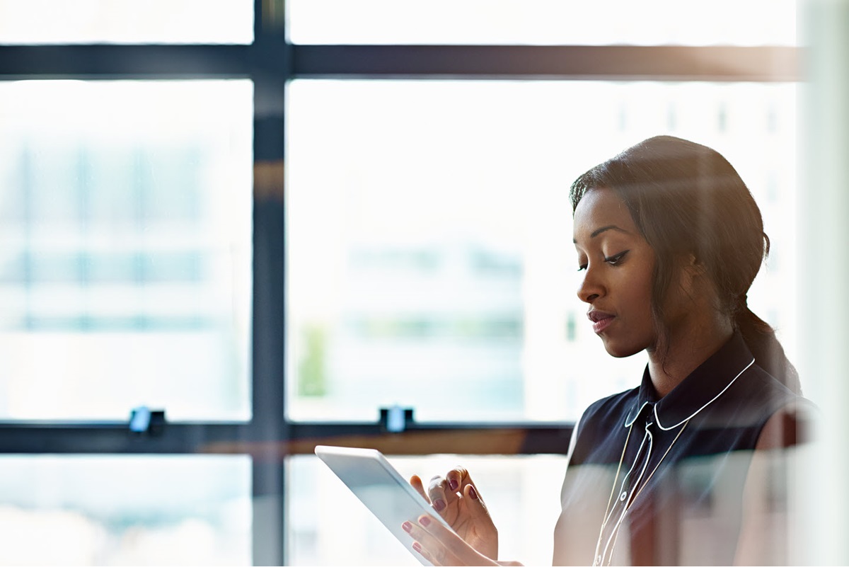 A businesswoman browses files loaded to the company's cloud document storage platform on her tablet.