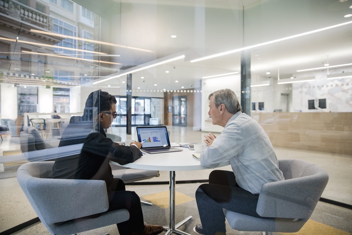 A loan manager and his client meet at an office to look over his finances.