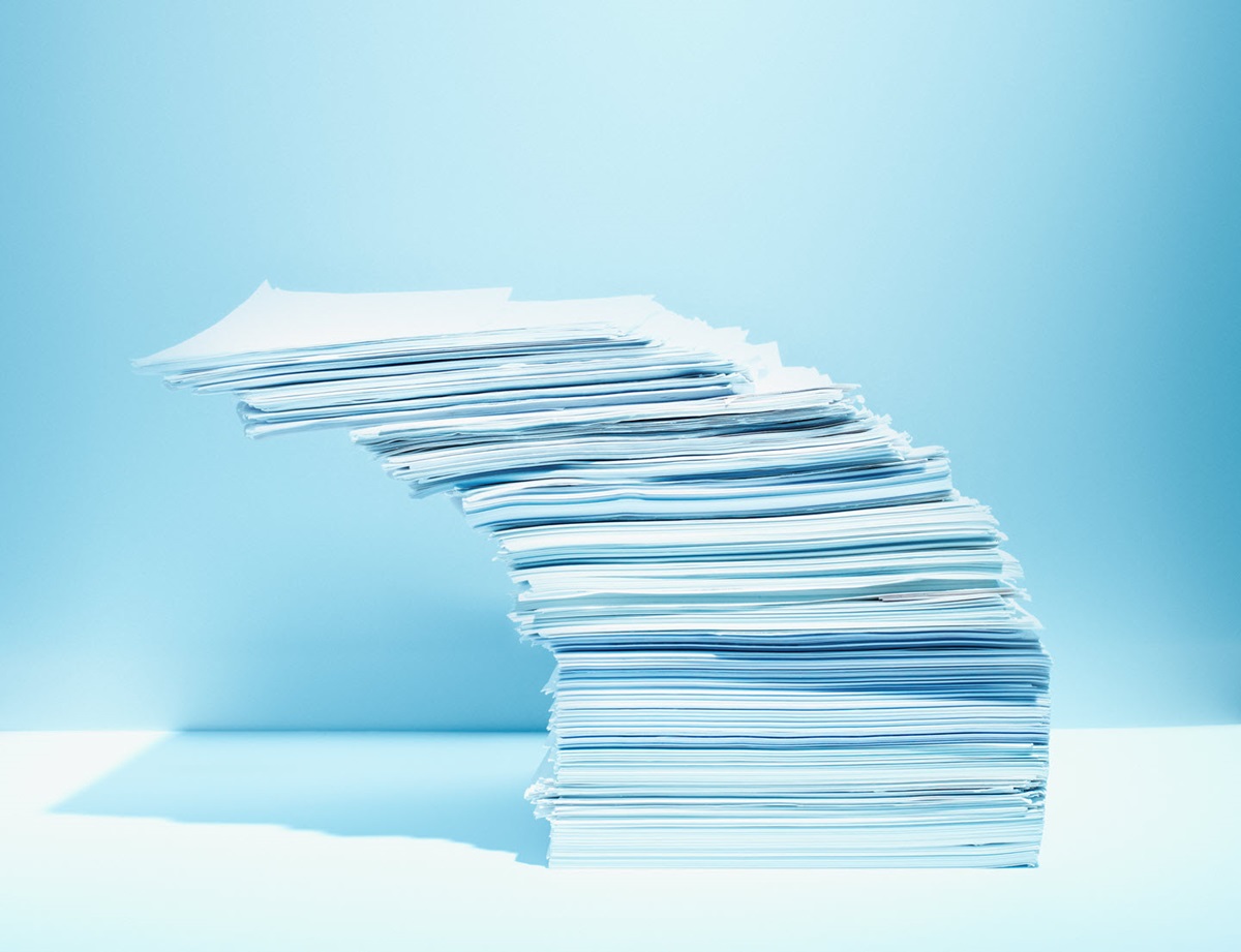An unbalanced stack of paper leaning precariously.