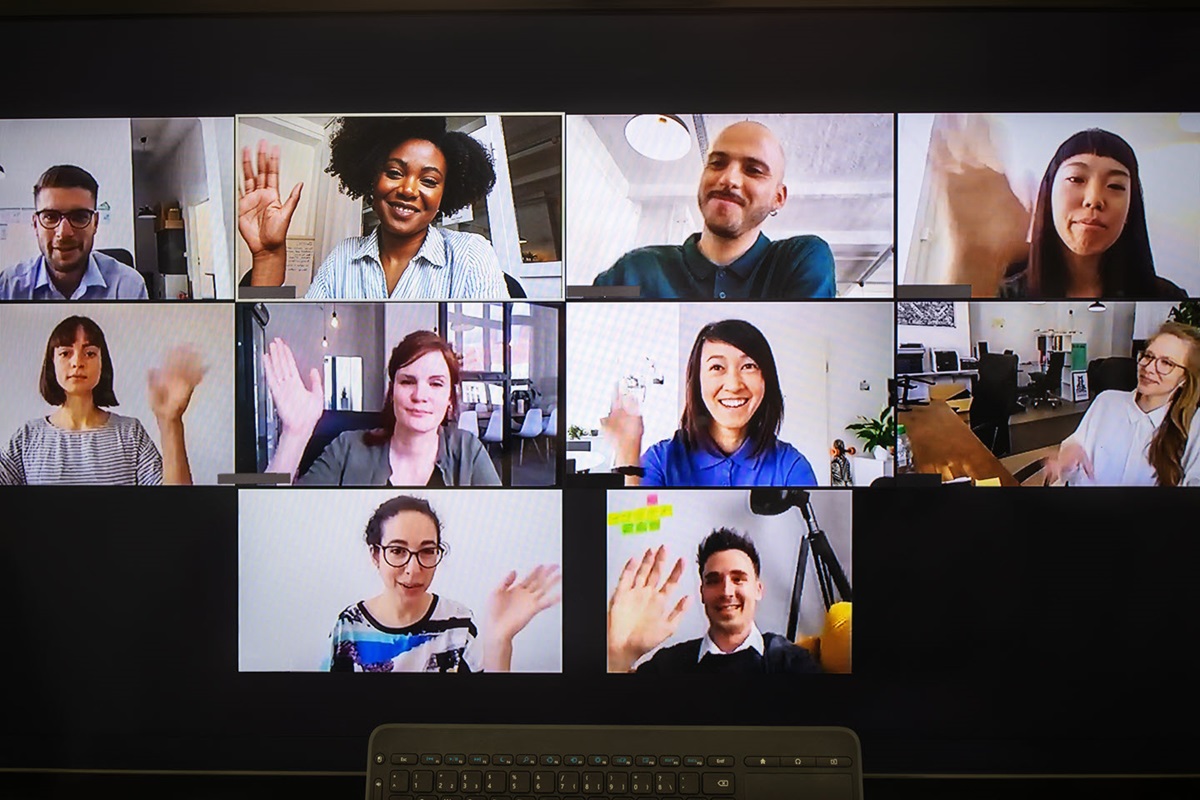 A computer screen showing multiple video conference participants waving.