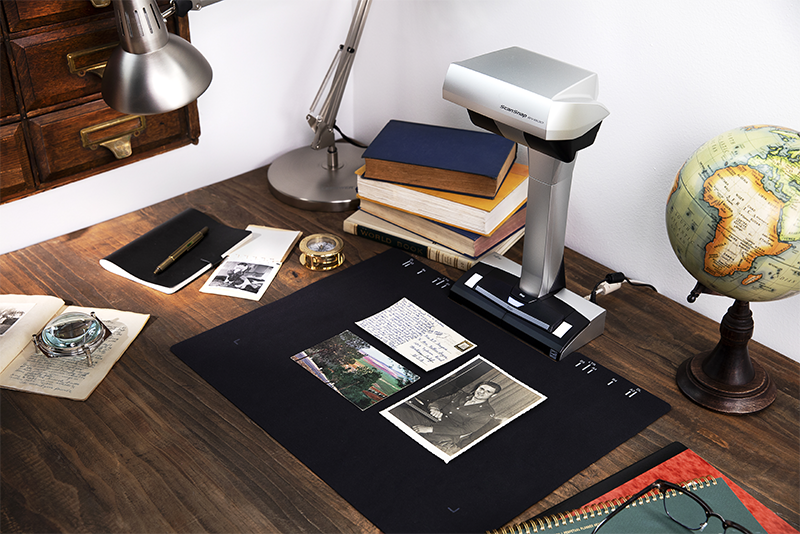 ScanSnap SV600 on a desk scanning three different photographs