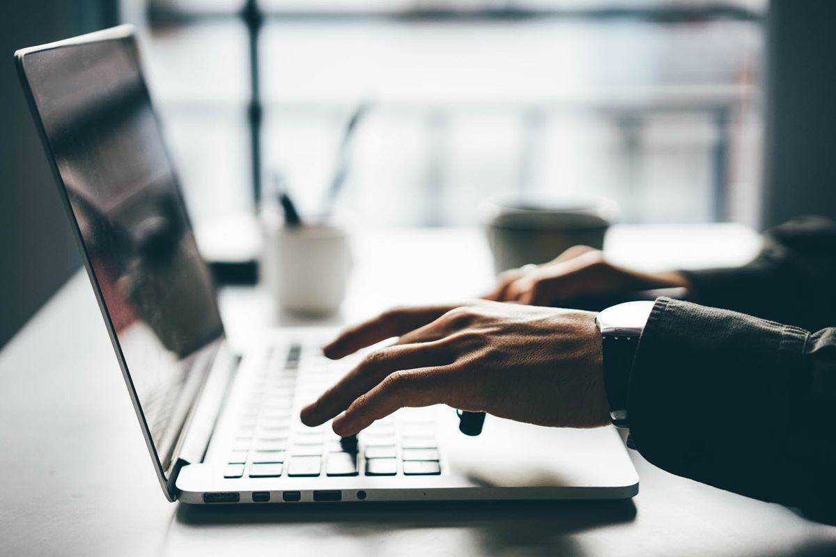 An employee checks their email on a laptop, which is one of many unstructured data examples.