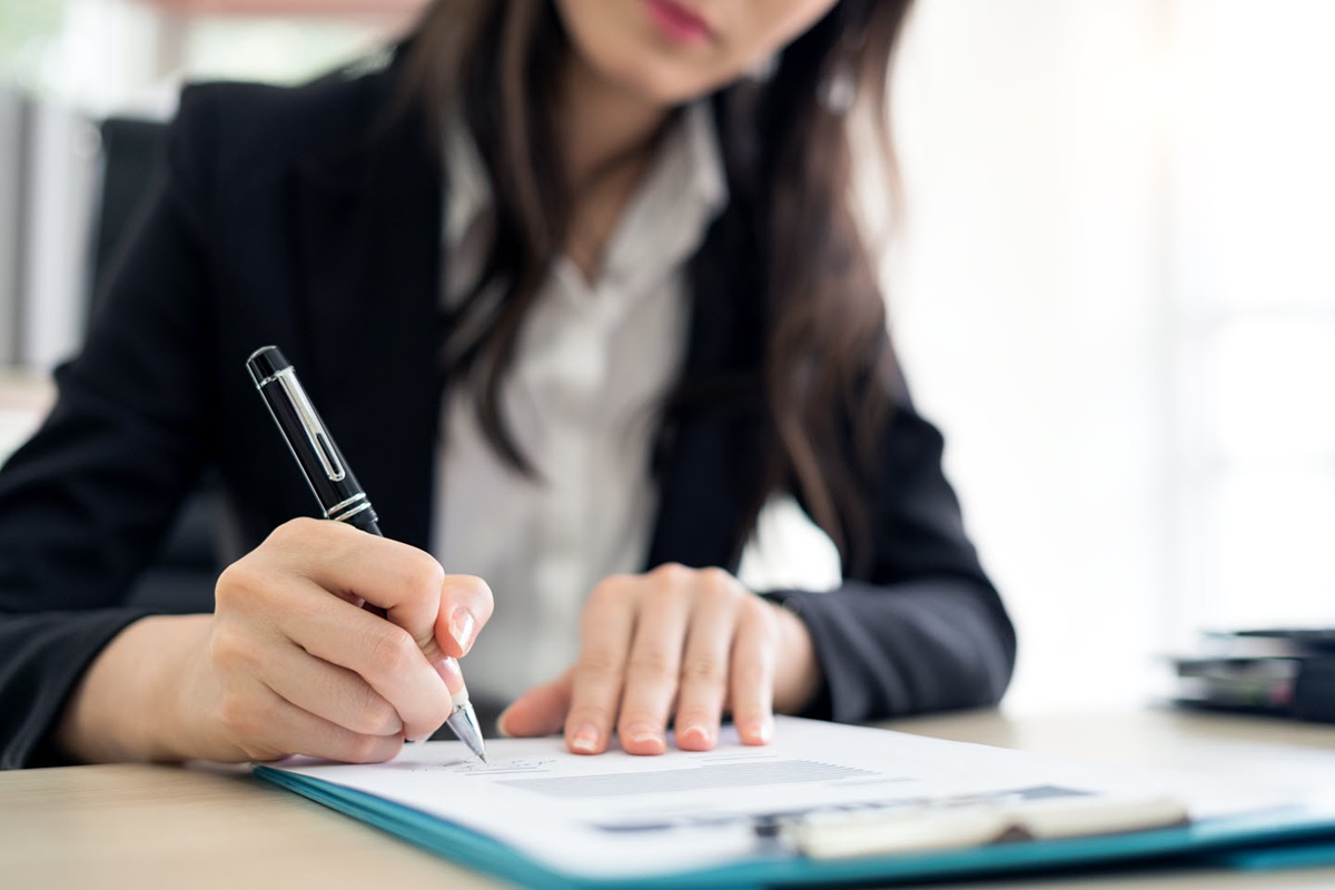 A woman filling out a form on a clipboard.