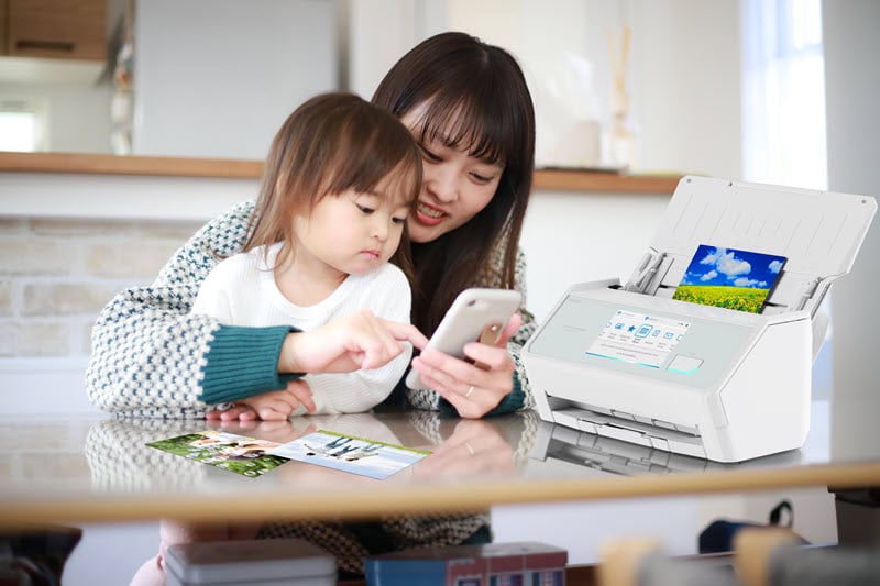 Asian mother with toddler near ScanSnap scanner. 