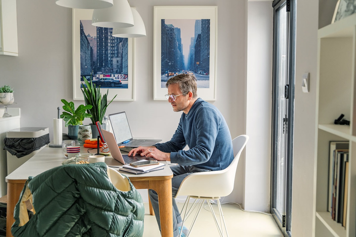 Man sitting at home desk working on a computer. 