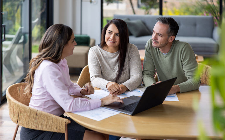 Hispanic couple listening to a female business consultant. 