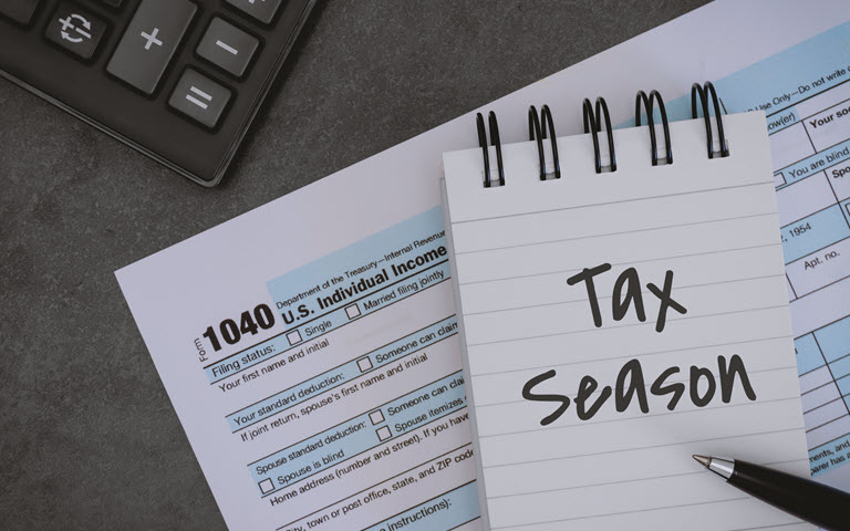 Tax Season Written on Notepad and Printed Tax Form