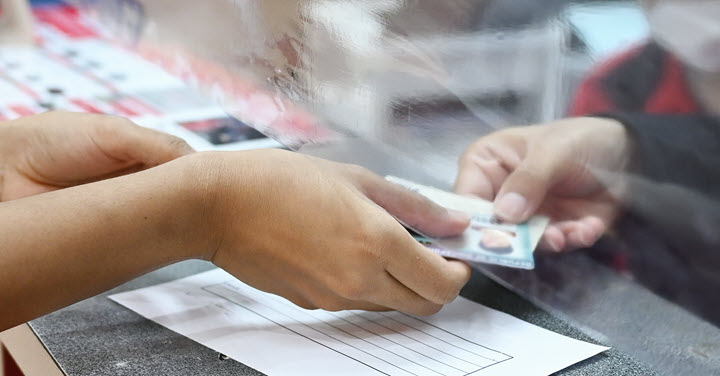 Person handing another person an ID card. 