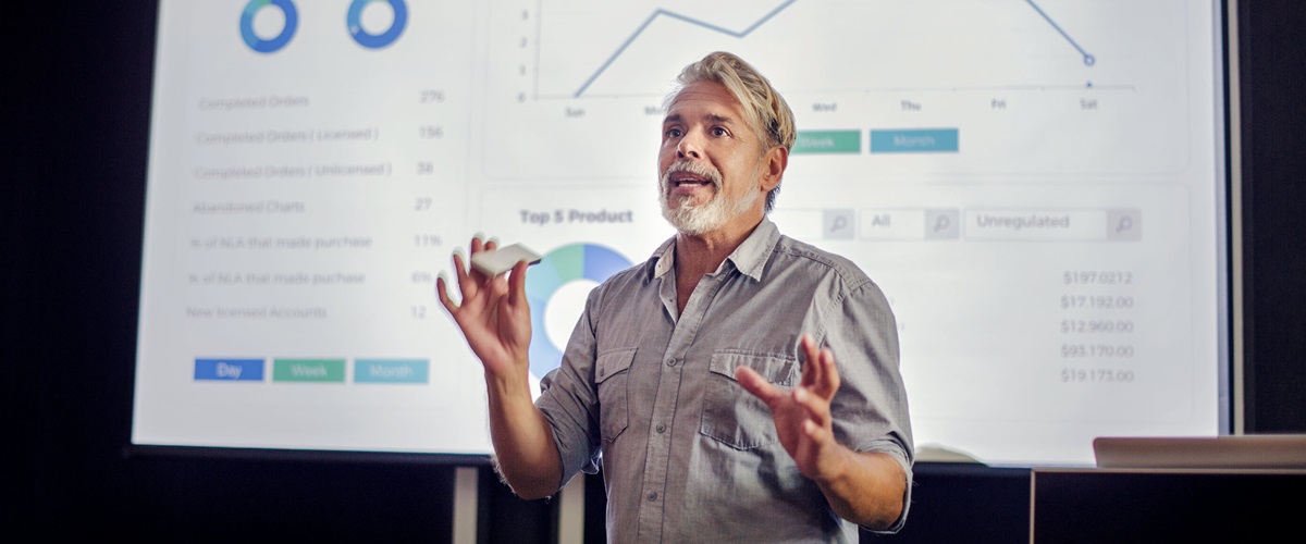 A businessman gives a sales presentation to members of the board.