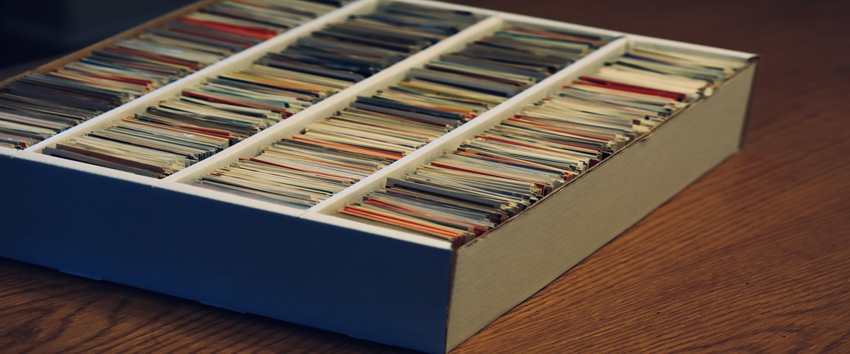A cardboard box with four rows packed full of trading cards.