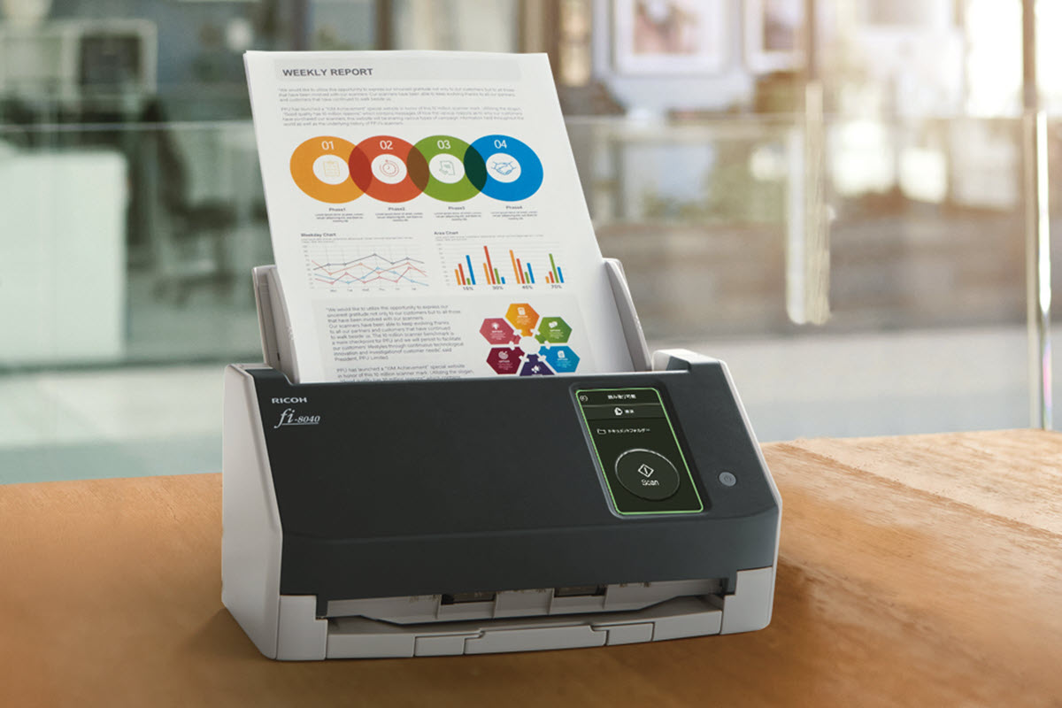 fi-8040 document scanner sitting on a desk with colorful document ready to be scanned. 