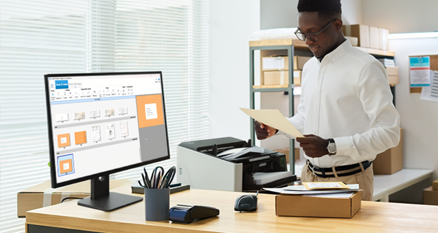 A man holding a paper at a work station with PaperStream Capture Pro Software  UI on screen and a Ricoh fi-8950 scanner nearby.